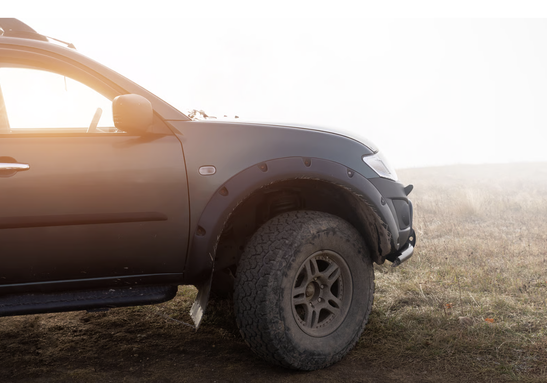Detalhe da roda e suspens&atilde;o de uma picape preparada para enfrentar terrenos irregulares e uso intenso.